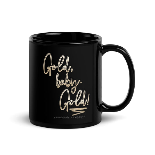 Glossy black coffee mug printed with the text: Gold, baby. Gold! in gold script lettering